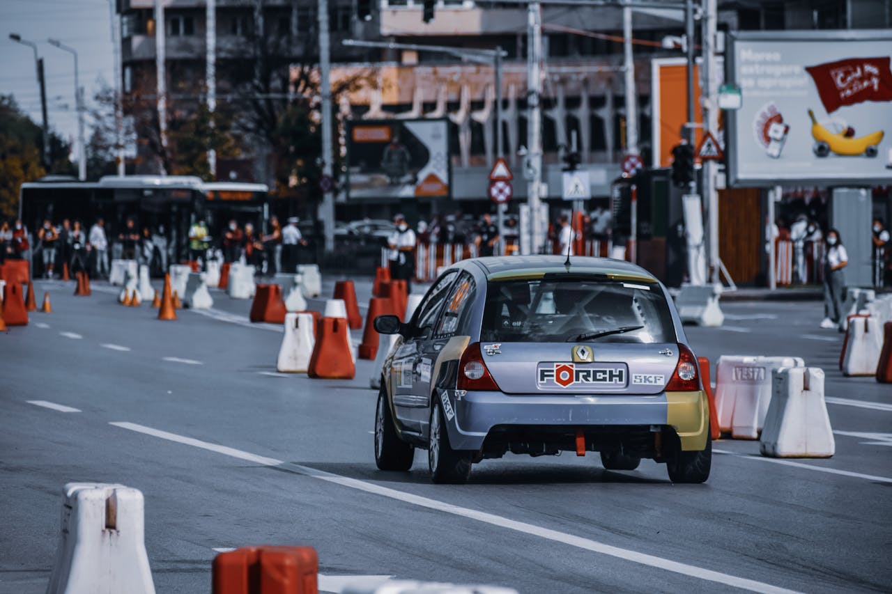 Dynamic city street race with car navigating through obstacles and a crowd watching.